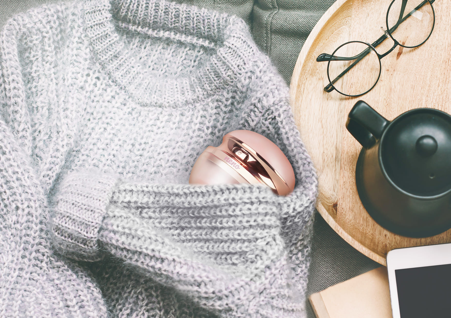 golarka do ubrań w swetrze i obok czajnik z okularami
