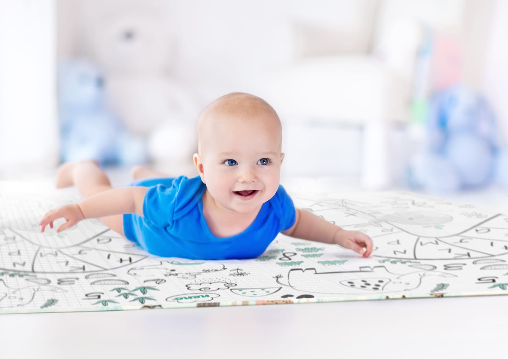 infant lying on tummy on mat