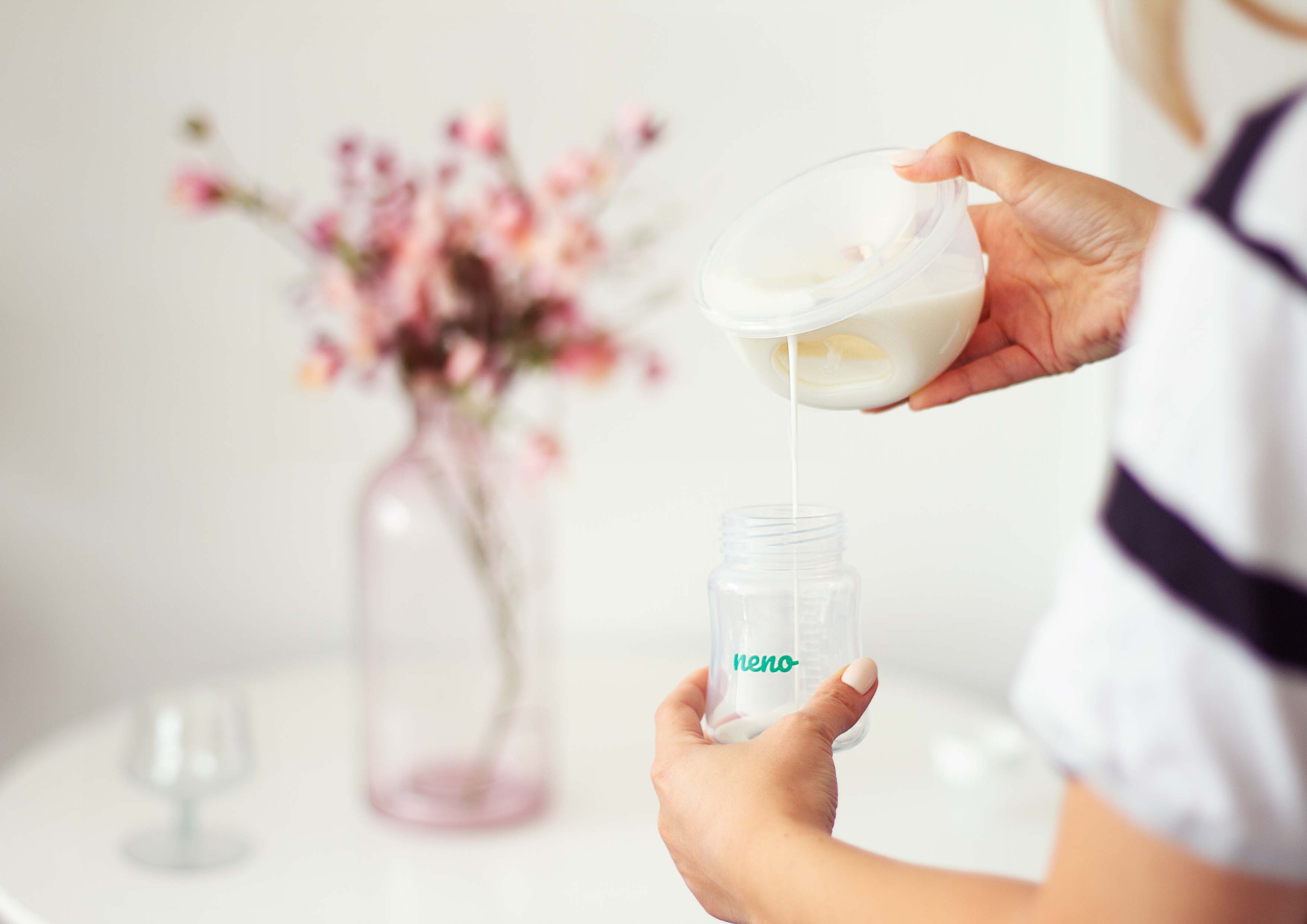 kobieta siedząca w koszuli i odciągajaca mleko