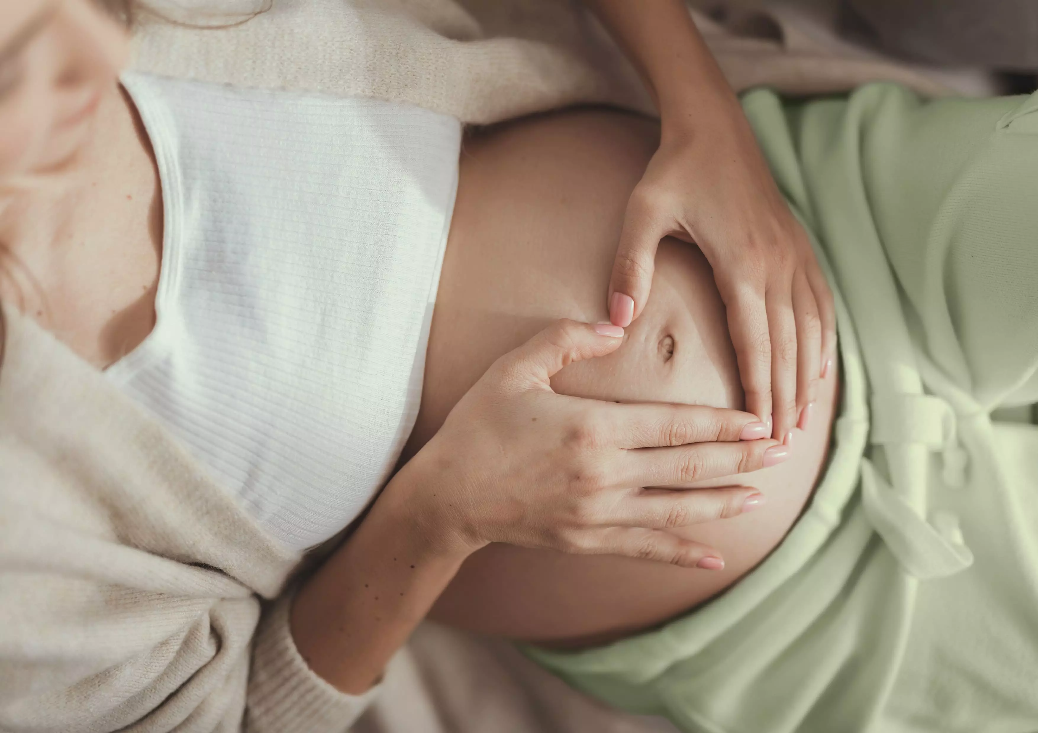 kobieta w ciąży trzymająca się za brzuch